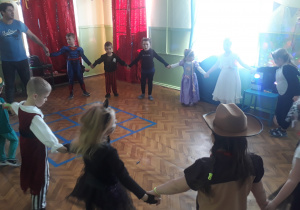 Na zdjęciu znajduja się dzieci z grupy Motylków oraz DJ Dzidziuś, dzieci trzymają się za ręce i tańczą